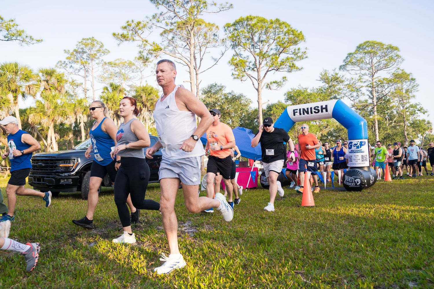 A group of people running in a race outdoors. The photo captures motion, energy,
