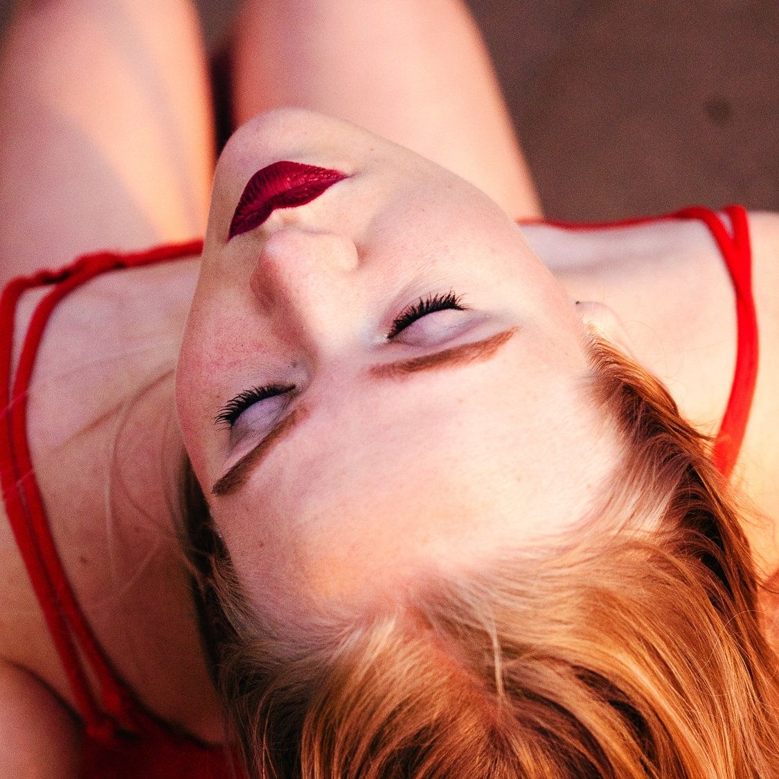 A photo of a woman with blonde hair, a red dress and red lipstick.
