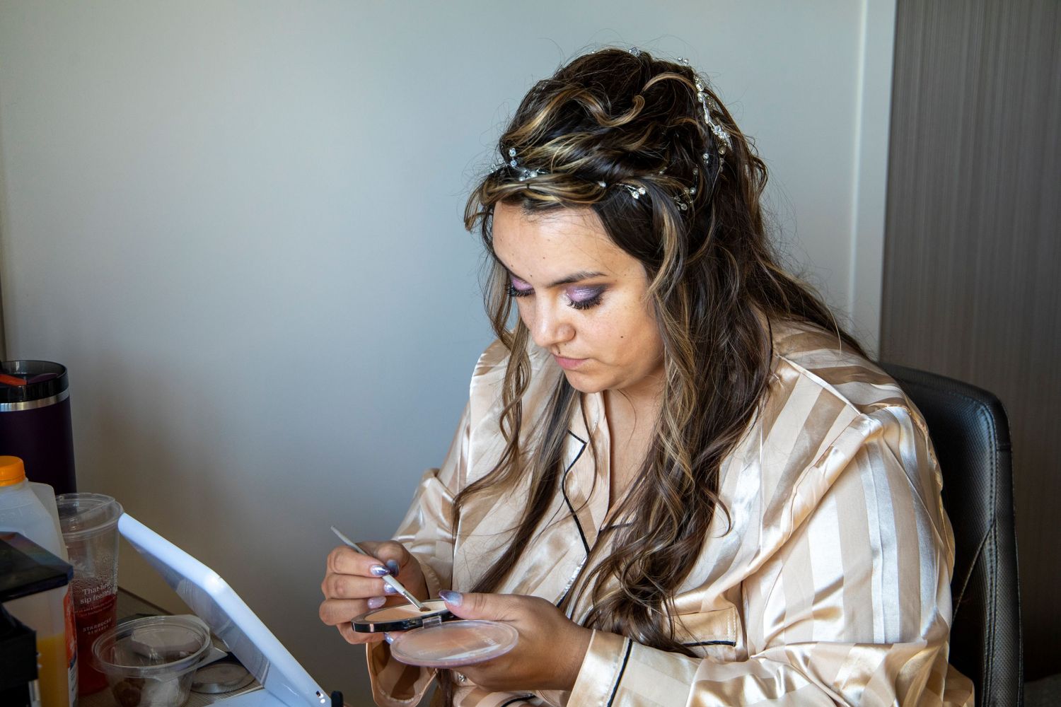 Person in a white satin robe sits on a couch while looking at their phone in multiple similar poses.