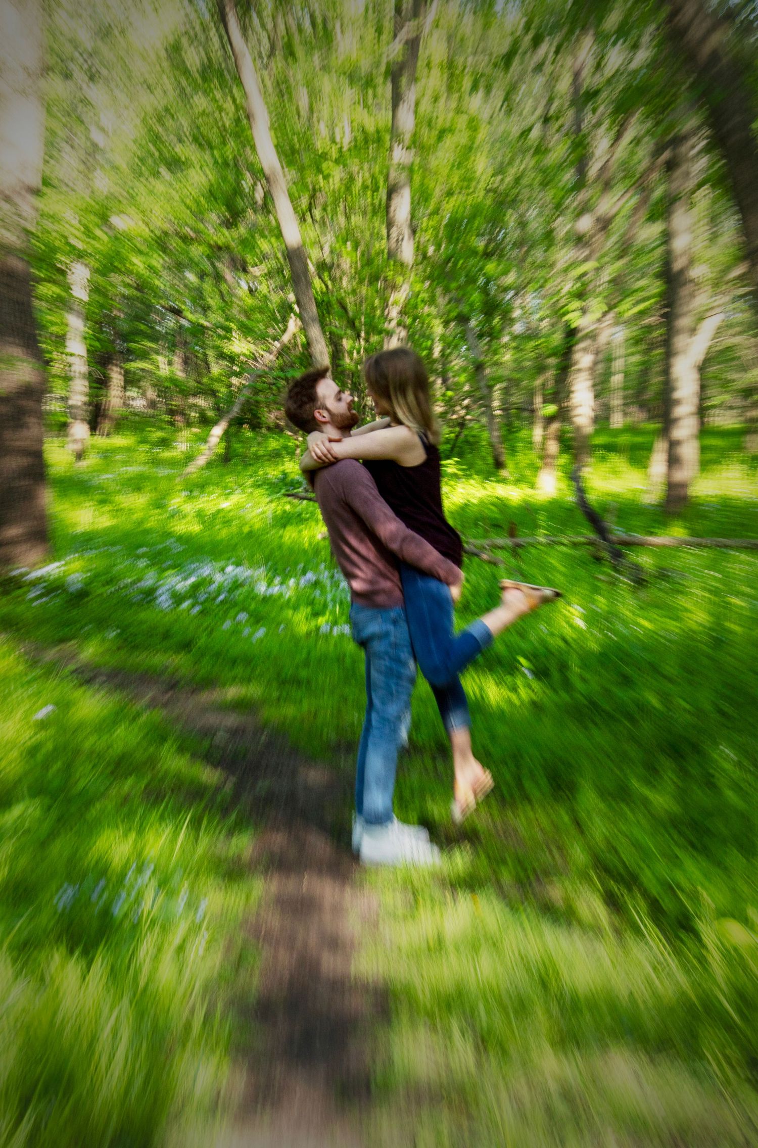 Motion-blurred sequence of a person swinging from a birch tree branch in a lush green forest setting.