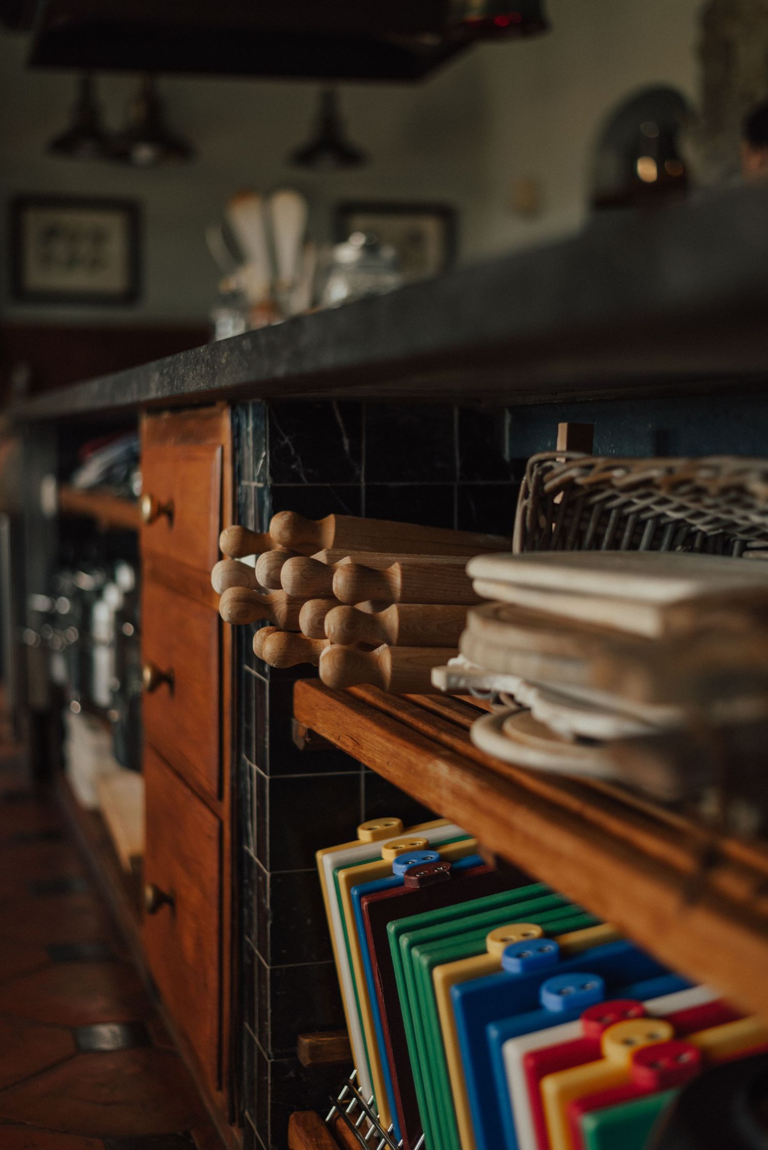 A series of file folders in various colors arranged neatly in a wooden filing cabinet drawer with warm lighting.