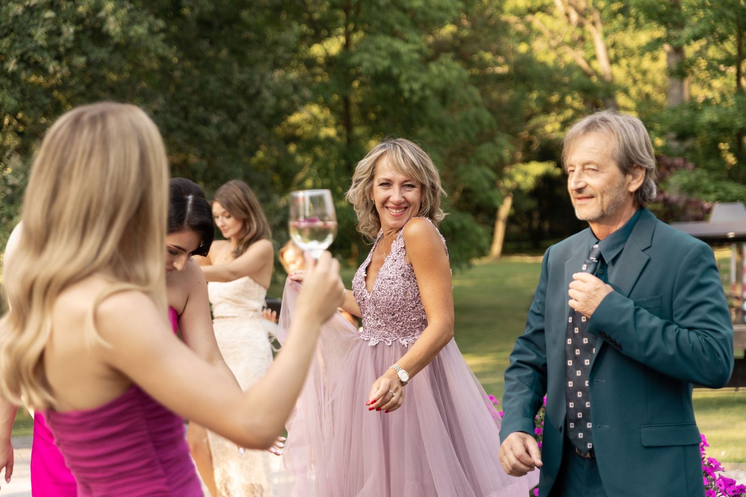 Wedding guests dancing and celebrating together at an outdoor reception during golden hour.