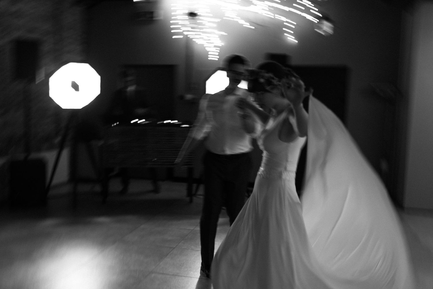 A black and white shot of a couple sharing their first dance together at a wedding reception.