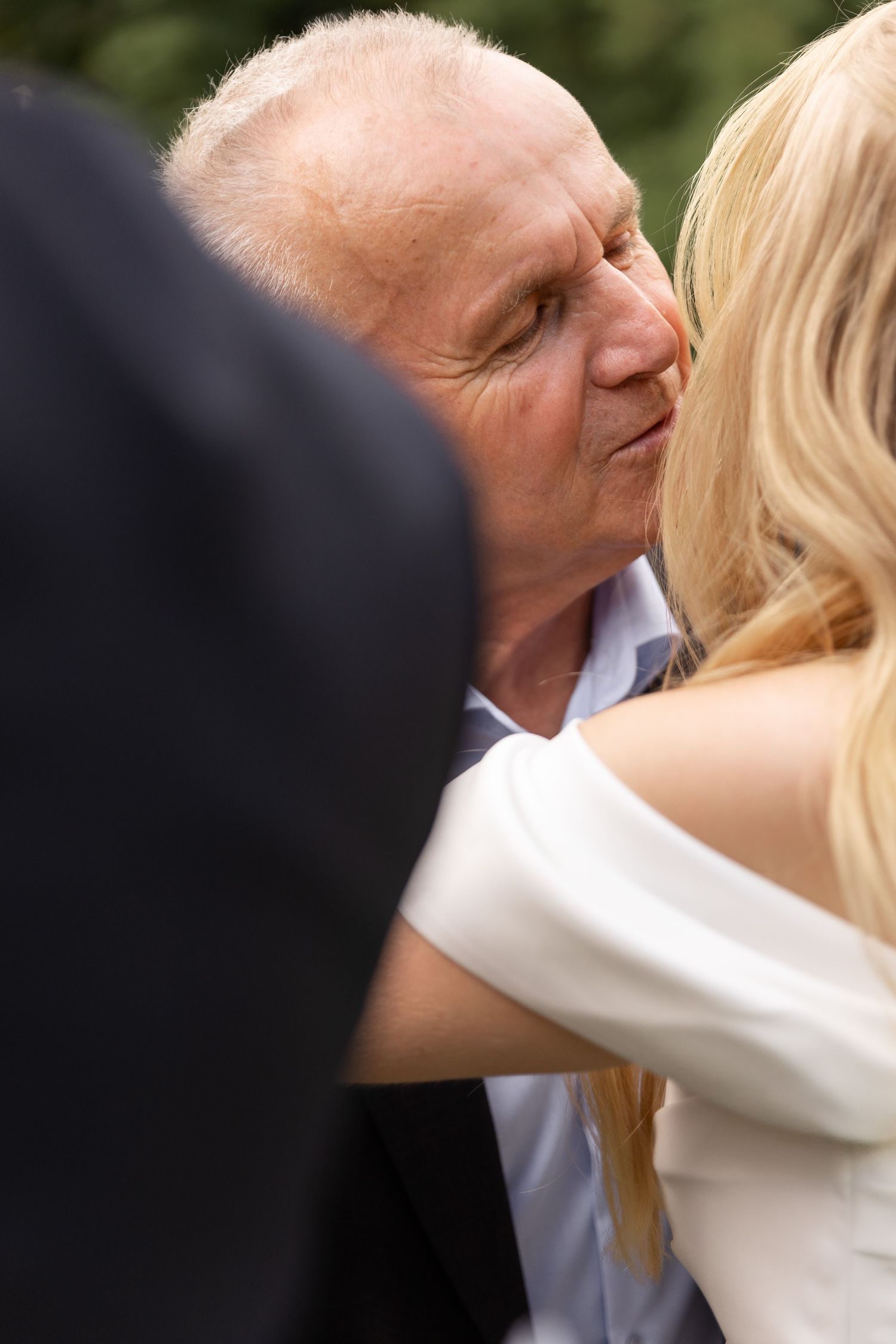 A sequence of close-up photos showing a couple in formal attire sharing a romantic kiss outdoors.