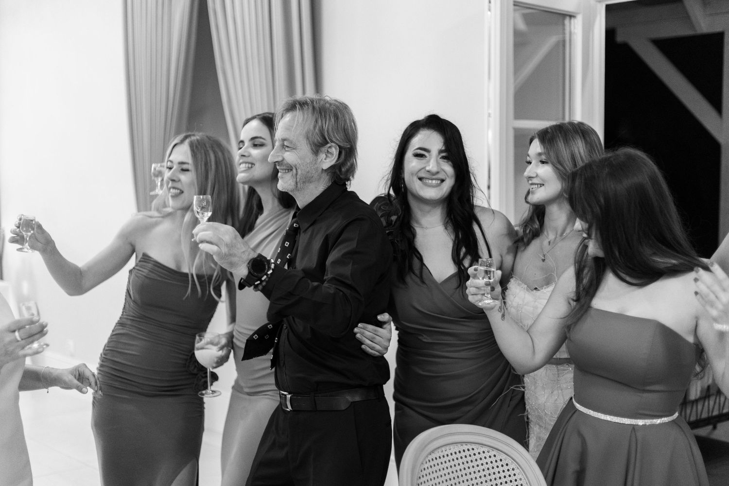 Black and white photo series showing wedding guests dancing and celebrating at a reception party.