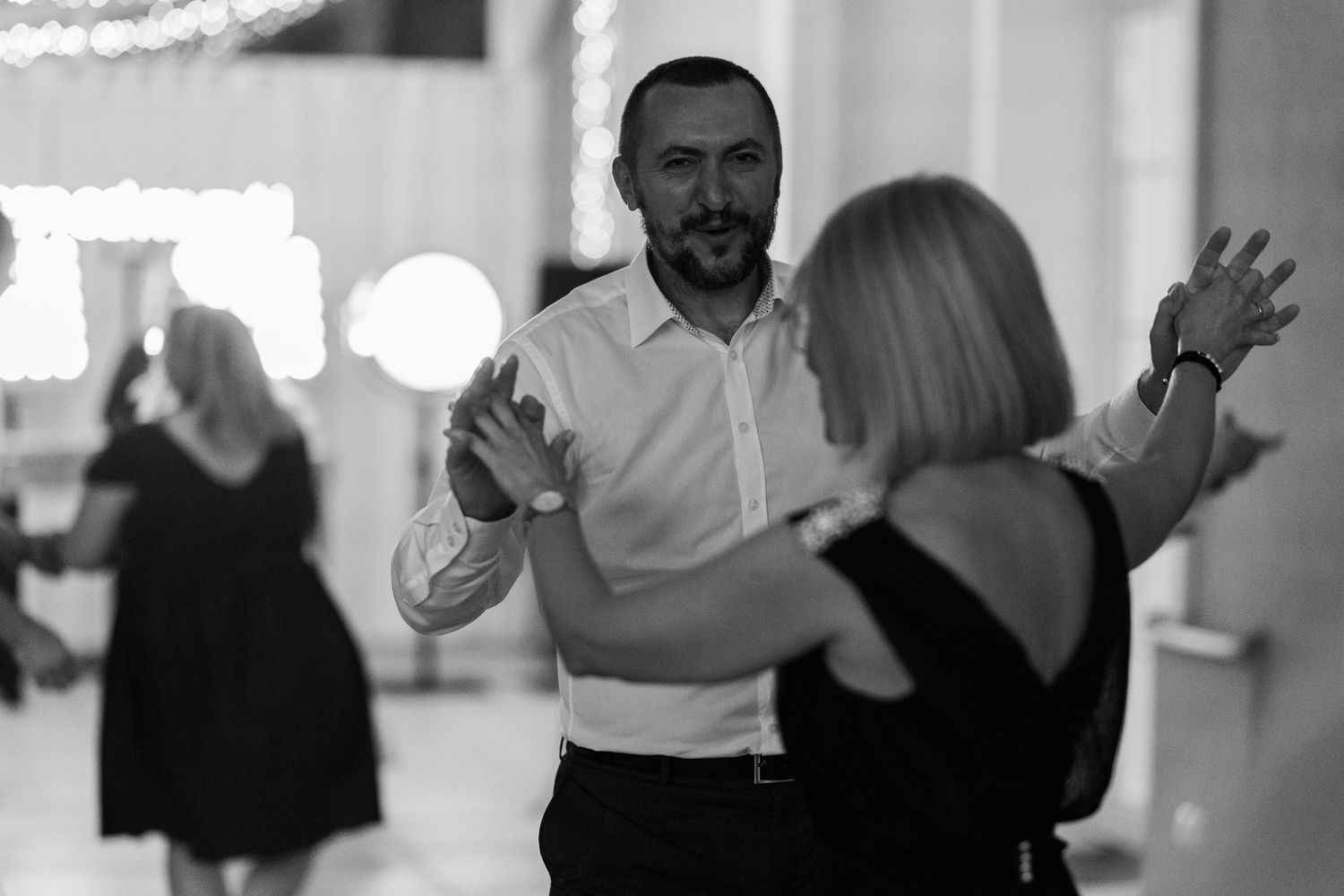 People dancing together in a black and white group dance class setting.