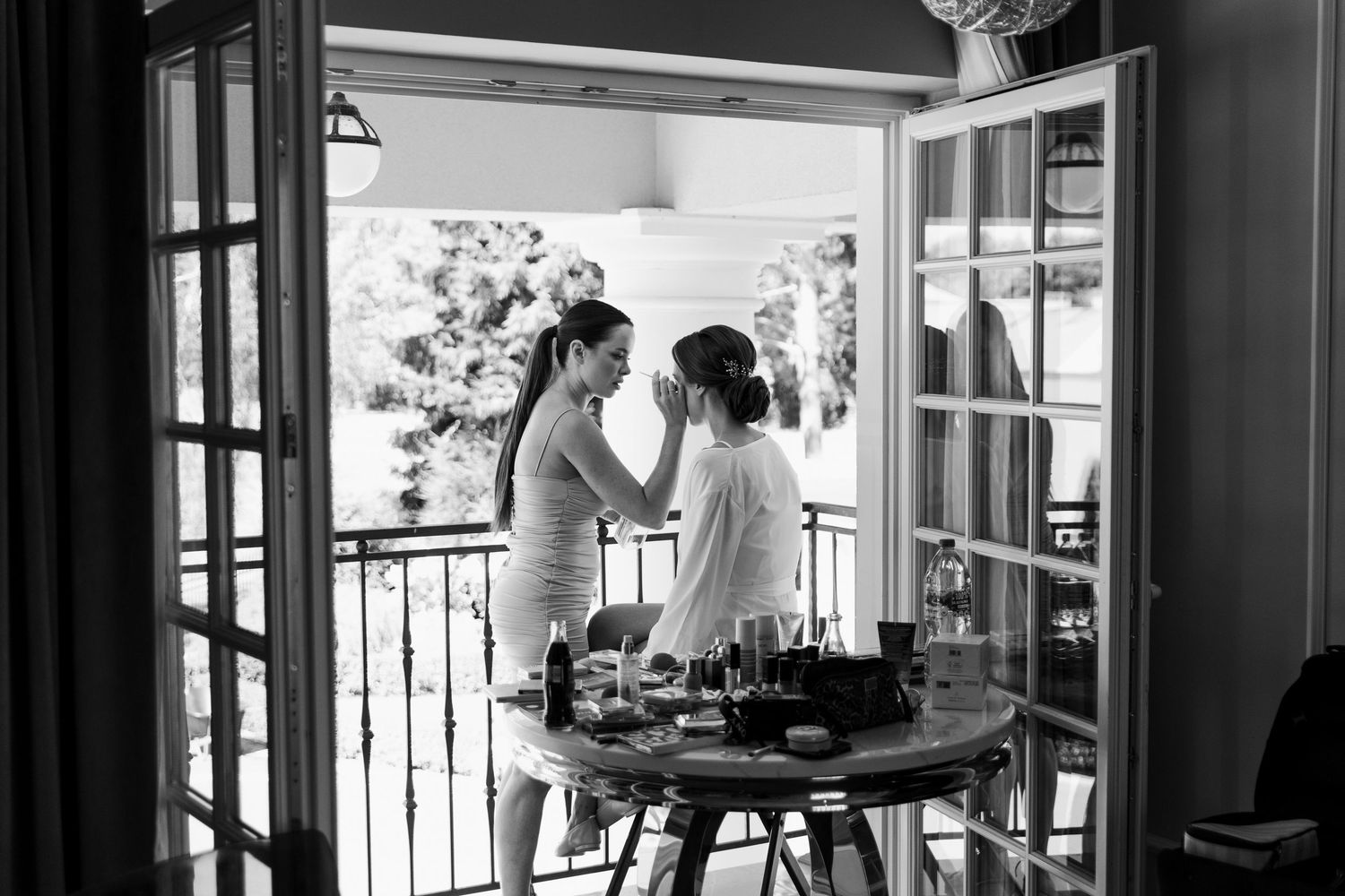 Two people stand together on a vintage balcony with black and white photography giving a romantic atmosphere.
