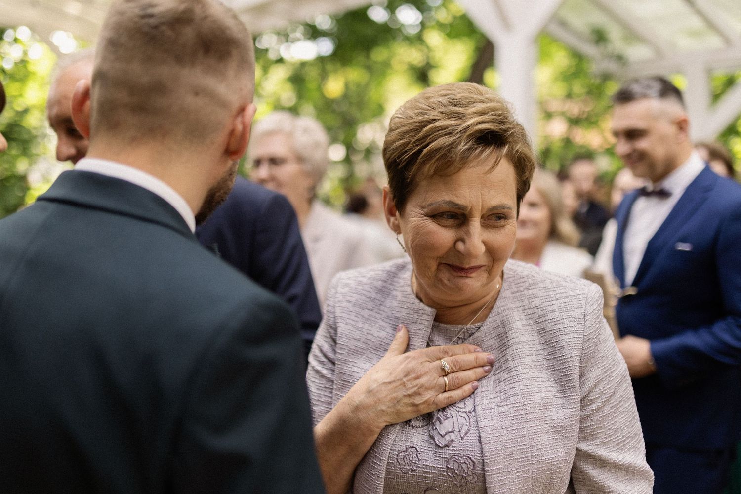 A heartwarming candid moment at a wedding shows an emotional exchange between two people in formal attire.