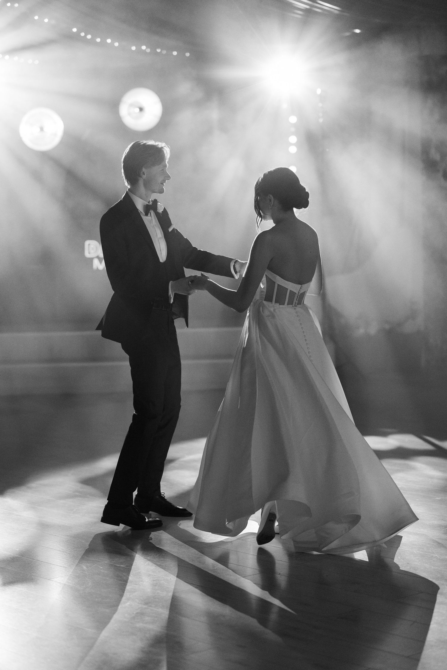 A black and white photo sequence shows a couple's romantic first dance at their wedding reception in dramatic lighting.
