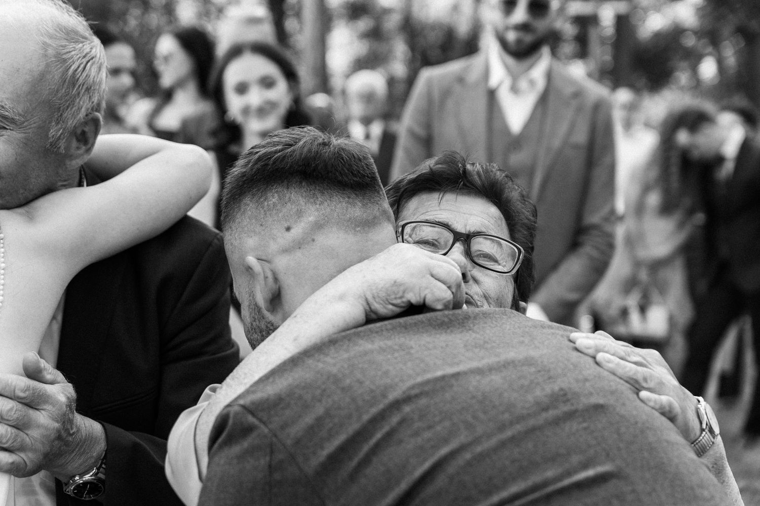 A series of black and white wedding photographs showing candid moments and embraces during a celebration.