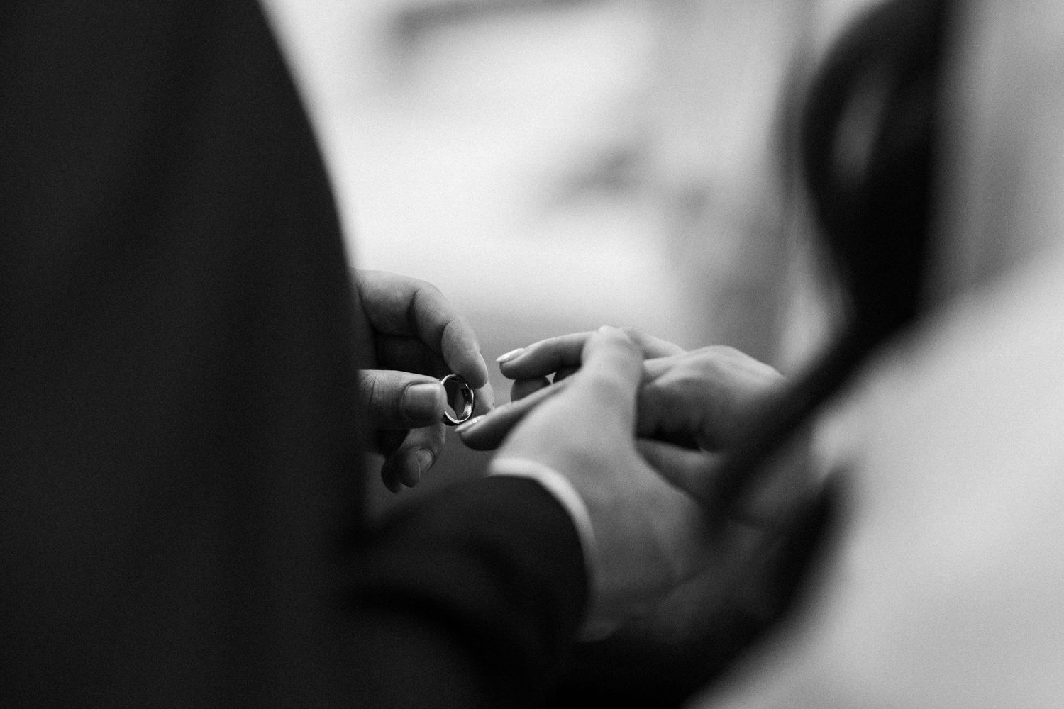 Close-up black and white shot of hands working with dental tools during a dental procedure.