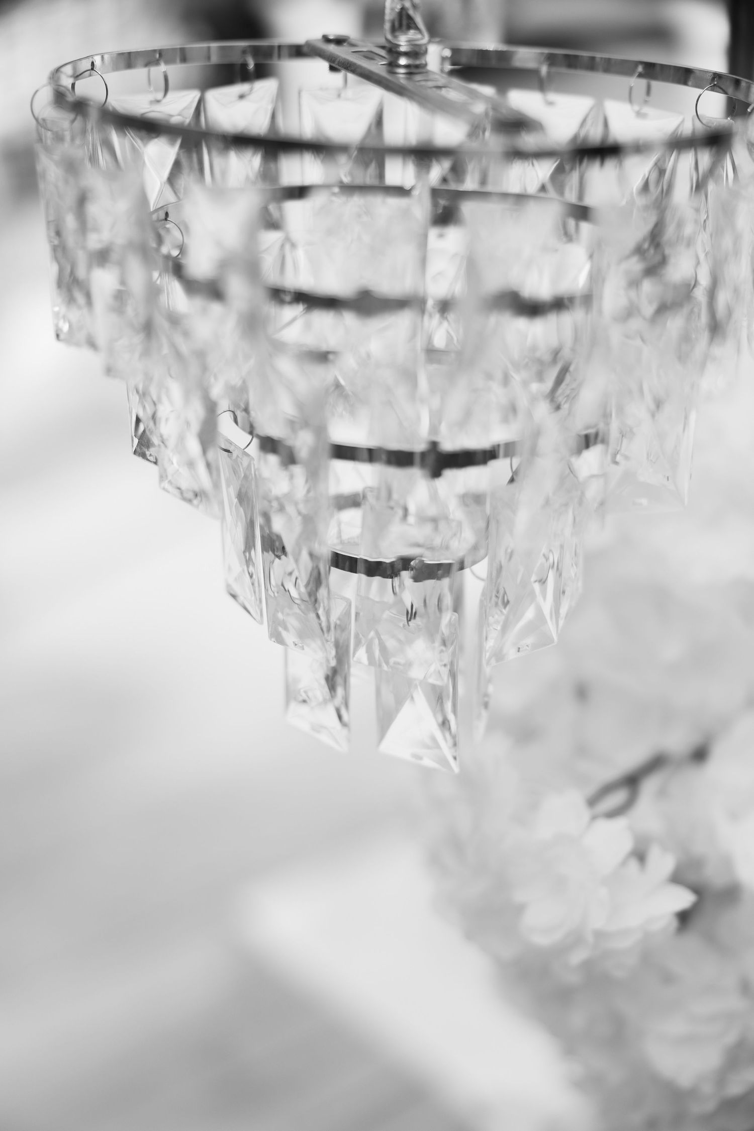 Elegant crystal chandelier with tiered glass pendants captured in black and white photography.