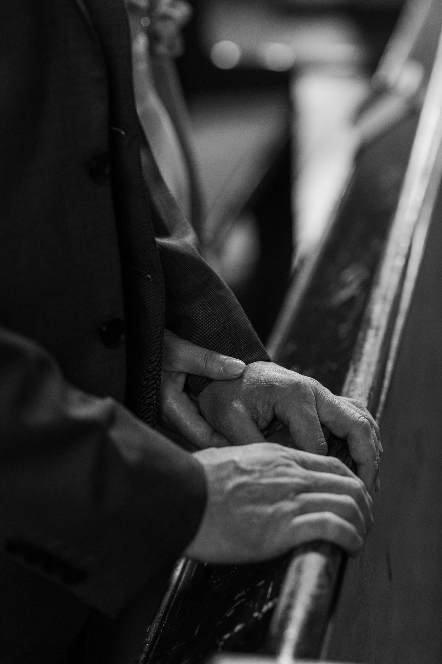 Close-up black and white photograph of hands playing a piano keyboard, showing delicate finger placement and technique.