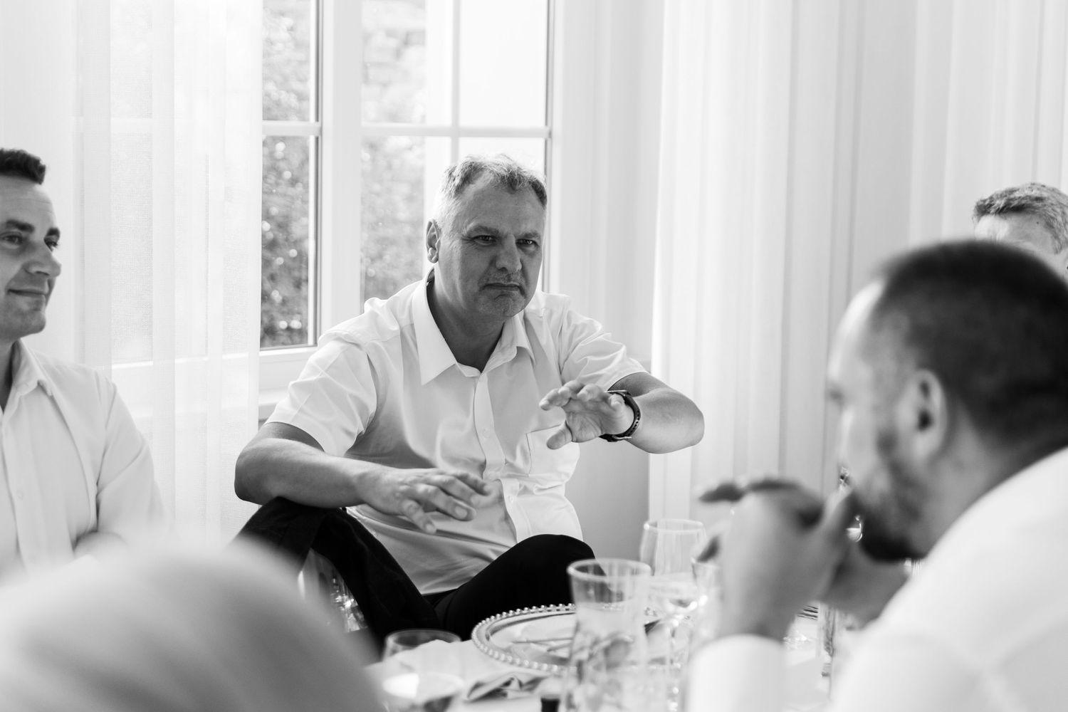 Business professionals engaged in discussion during a bright white conference room meeting.