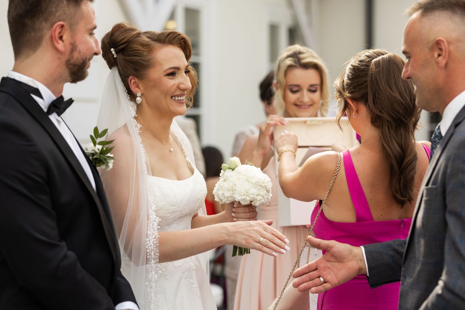 Wedding guests share joyful moments during a reception celebration with hugs and laughter.