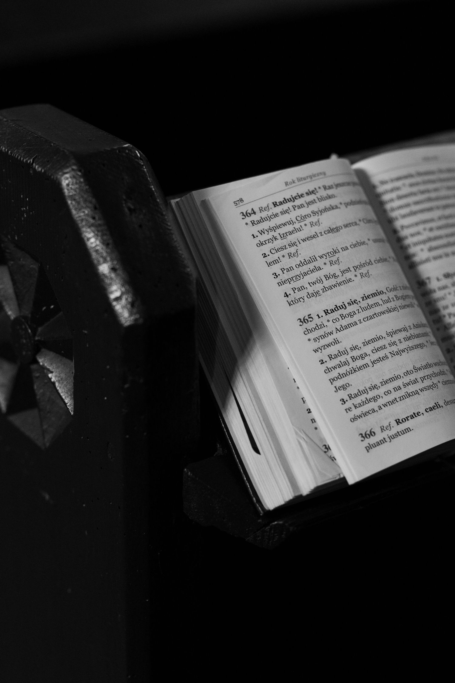 Black and white photographs showing open book pages in dark lighting with dramatic shadows.
