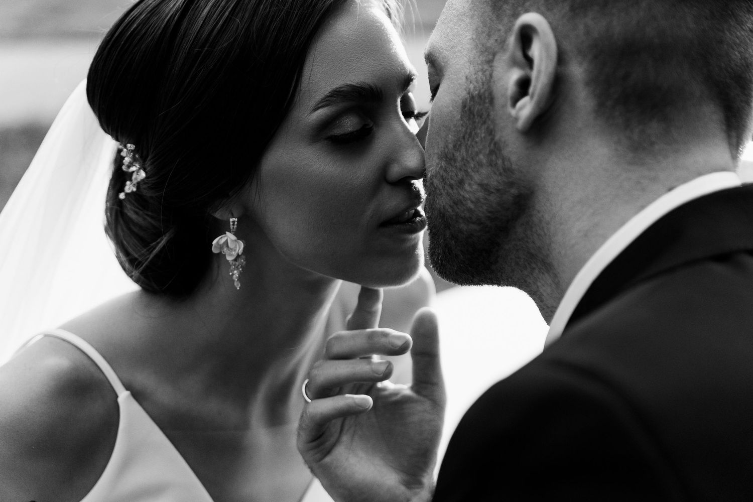 Artistic black and white close-up of a tender moment between bride and groom.