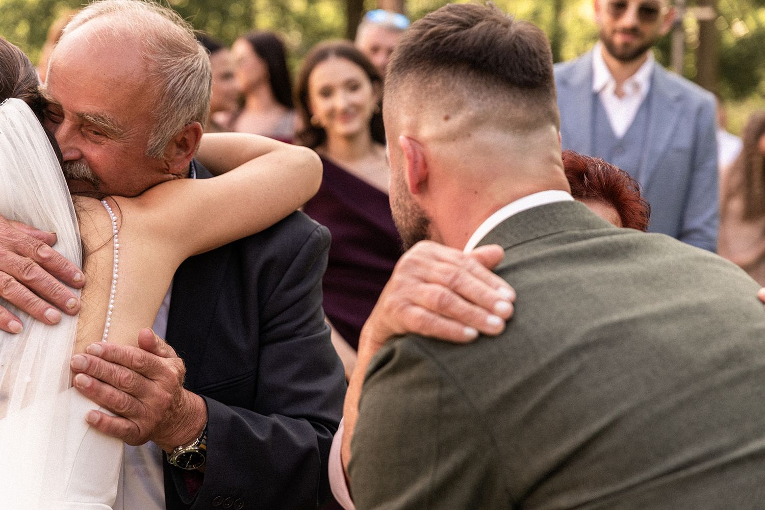 A sequence of photos showing wedding guests embracing and hugging at an outdoor celebration.