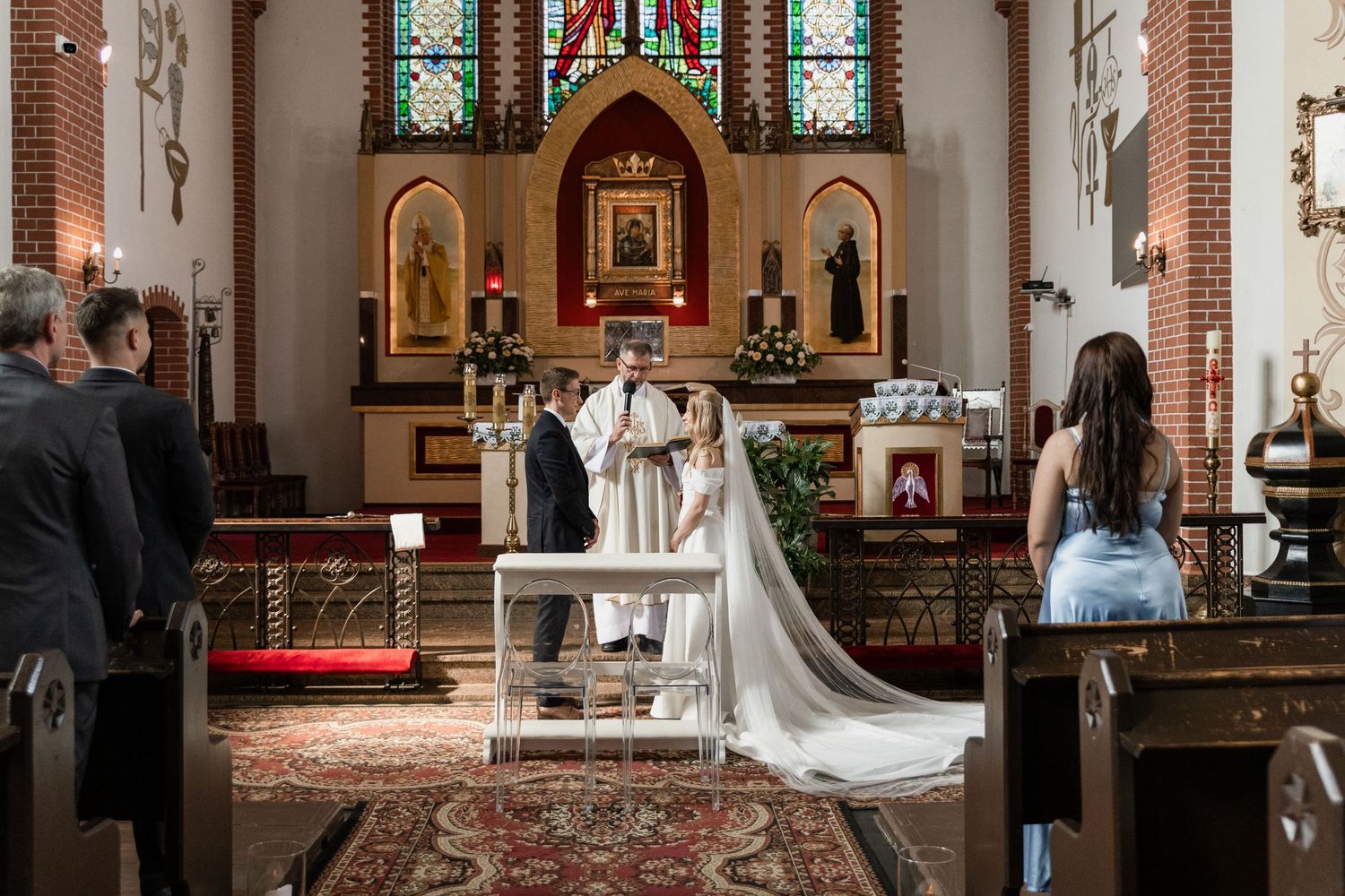 A traditional church wedding ceremony with the couple standing at the altar in a beautiful gothic cathedral interior.