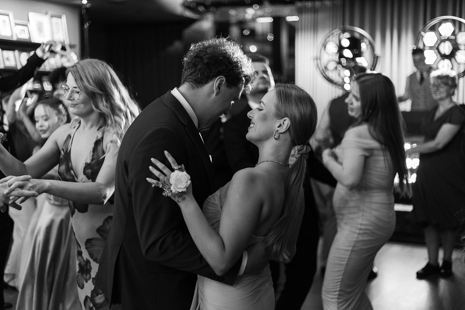 Couples dance together at a wedding reception in black and white photography.