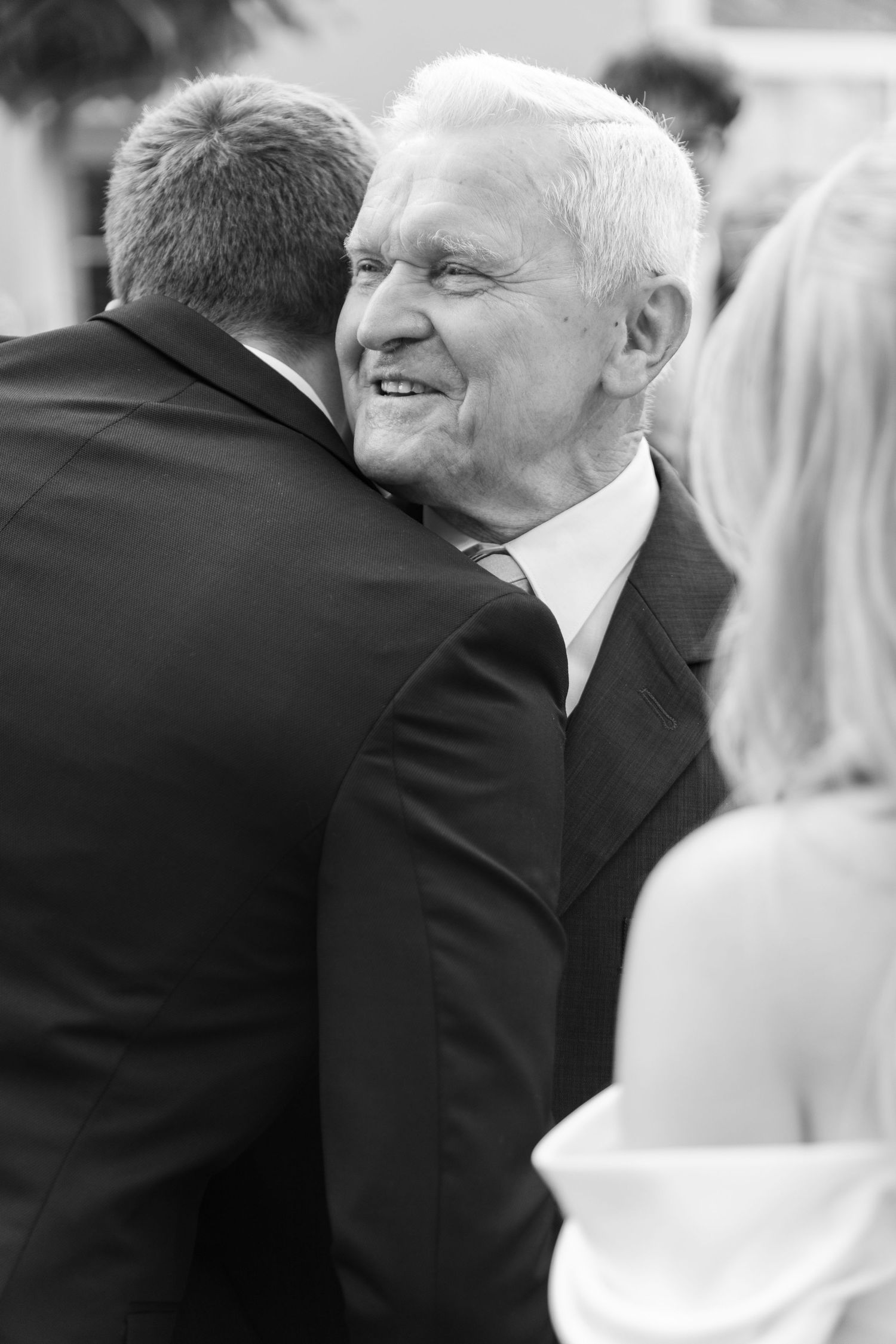 A series of black and white photos showing two people in formal attire embracing at what appears to be a special event.