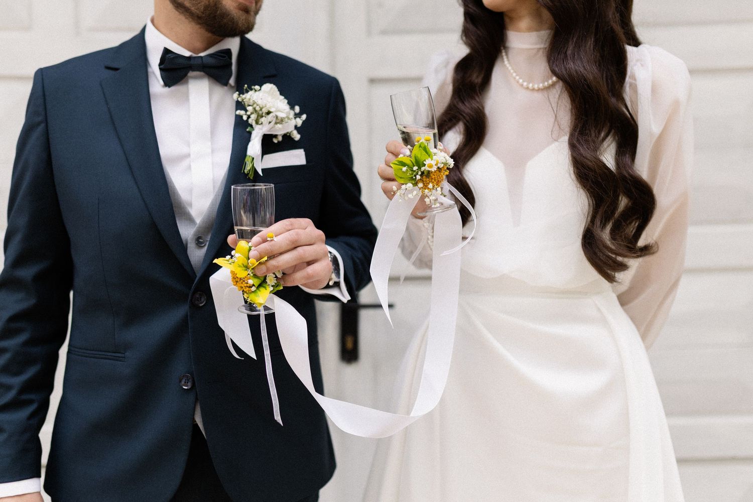 Close-up of bride and groom showing matching yellow flower corsage and boutonniere with their formal wedding attire.