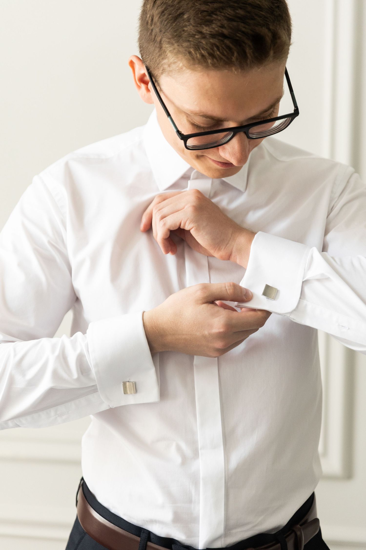 Person in white dress shirt smelling chocolate bar in sequence of three photos.