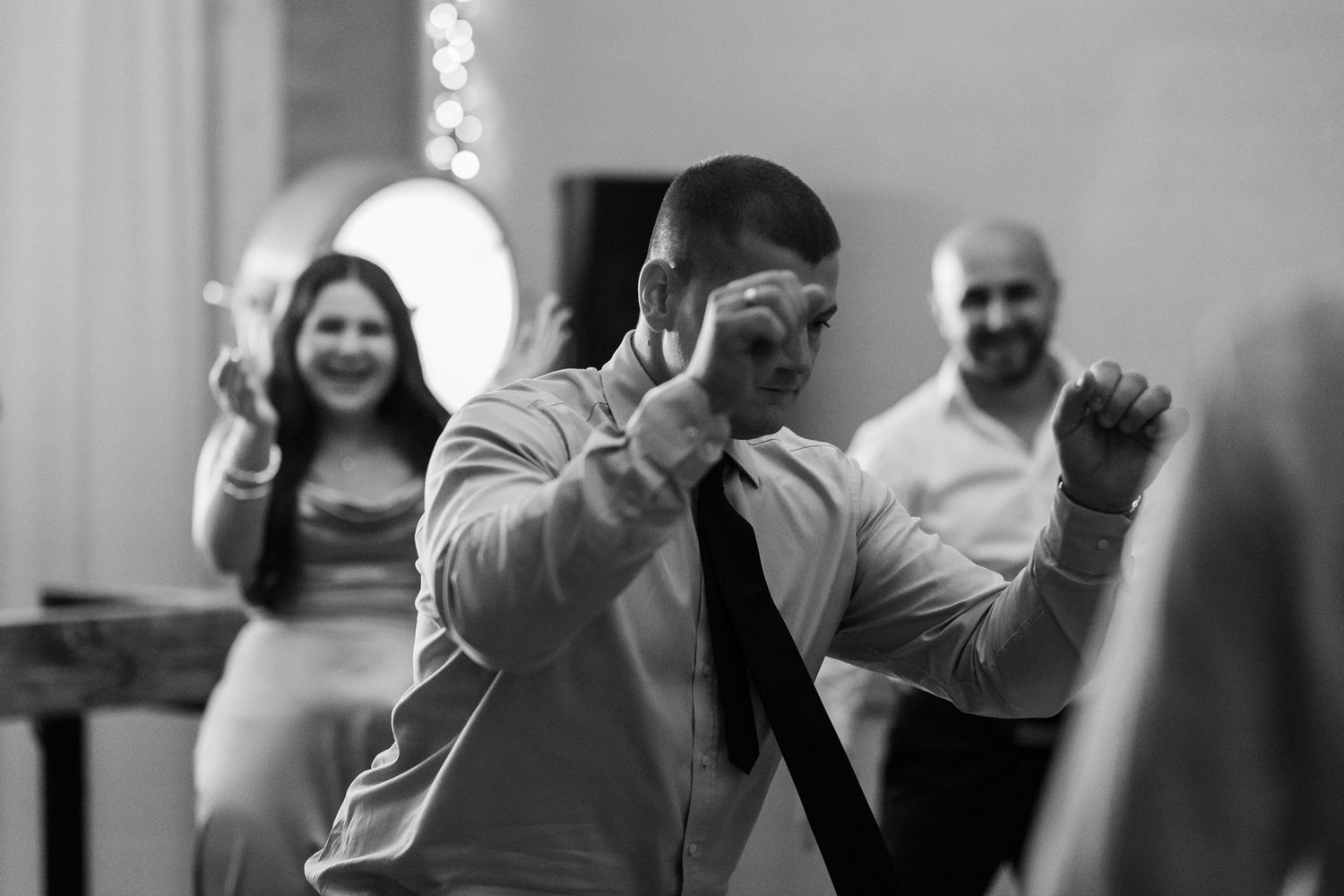 A black and white collage of candid moments showing people laughing and interacting at a social gathering.