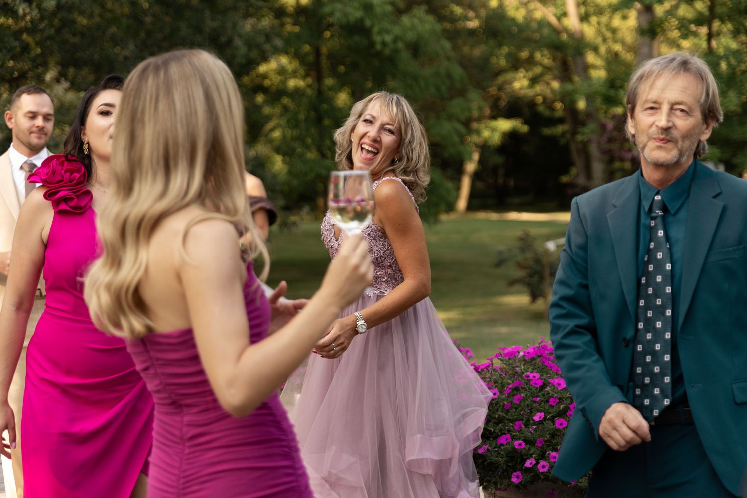 People enjoying themselves at an outdoor wedding celebration with natural lighting.