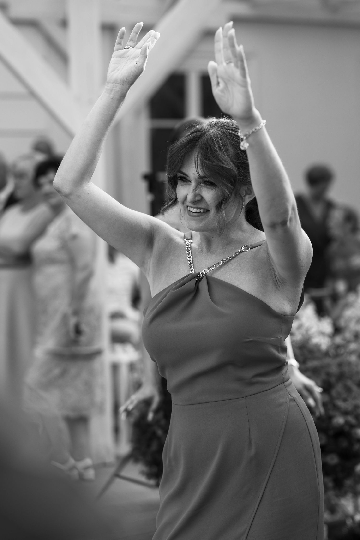 A series of black and white photos showing someone dancing joyfully with raised arms in a sleeveless dress.