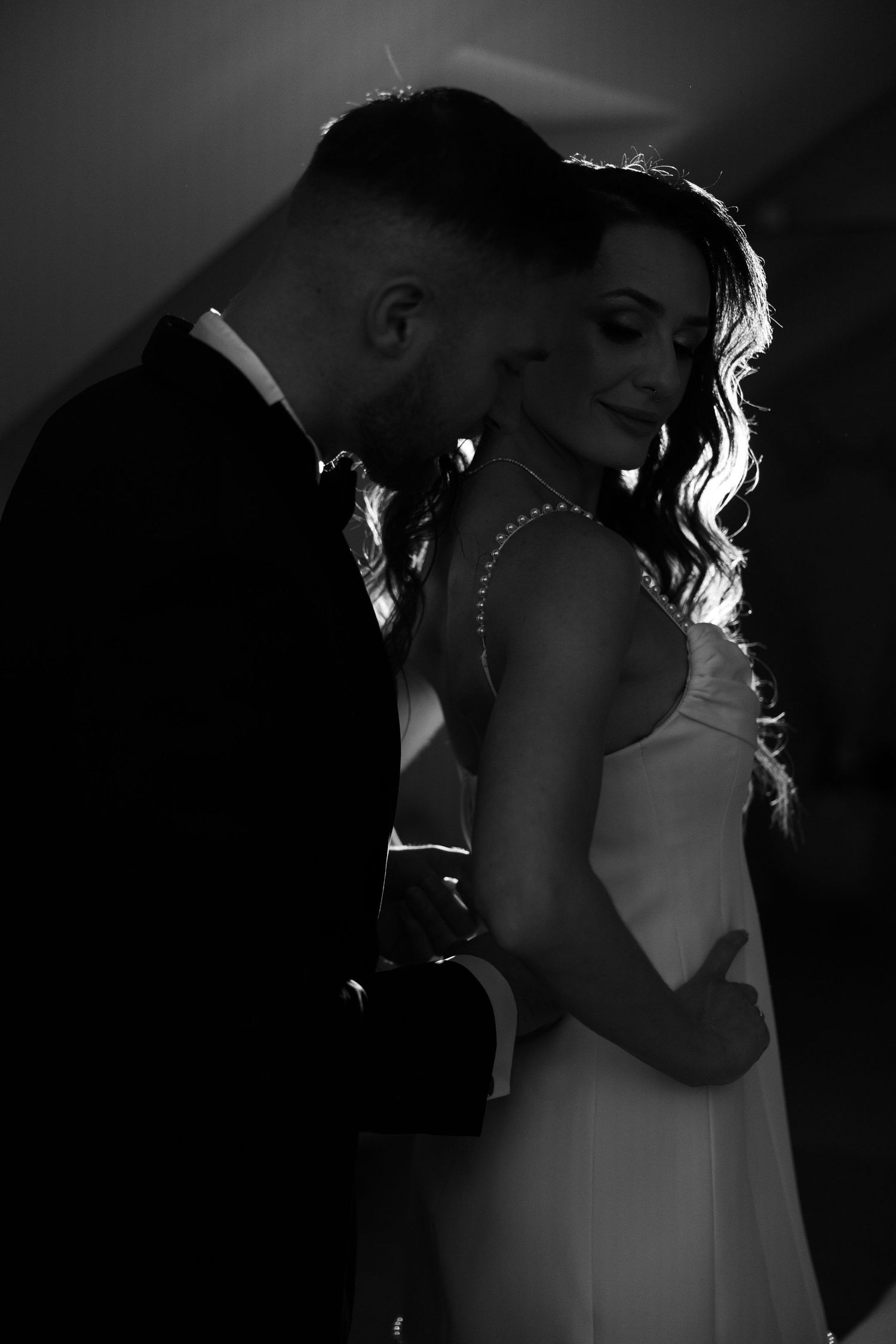 Black and white photo of a bride and groom sharing an intimate moment during their first dance at their wedding.