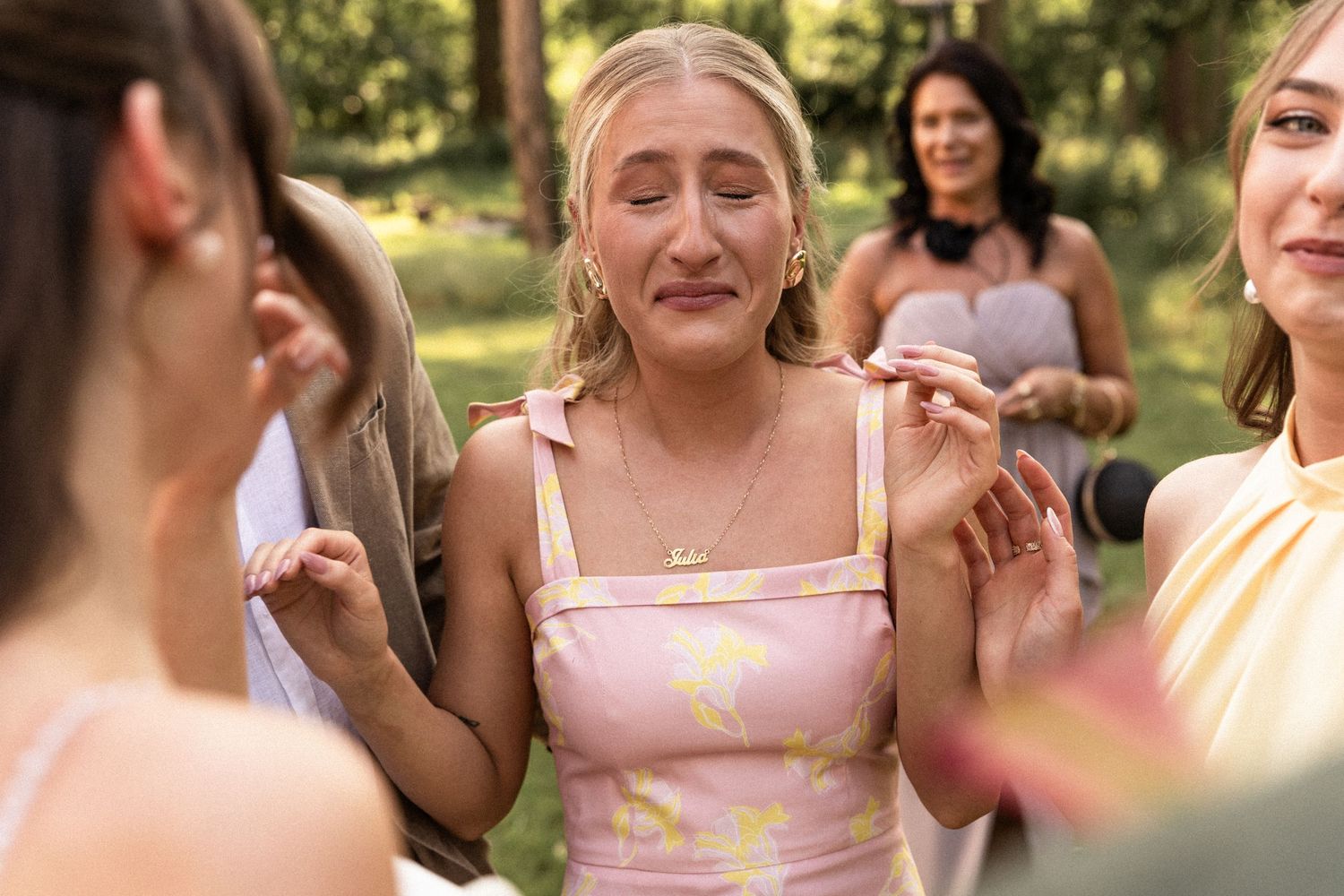 A group of friends enjoy a casual outdoor gathering on a sunny day while wearing summer dresses.