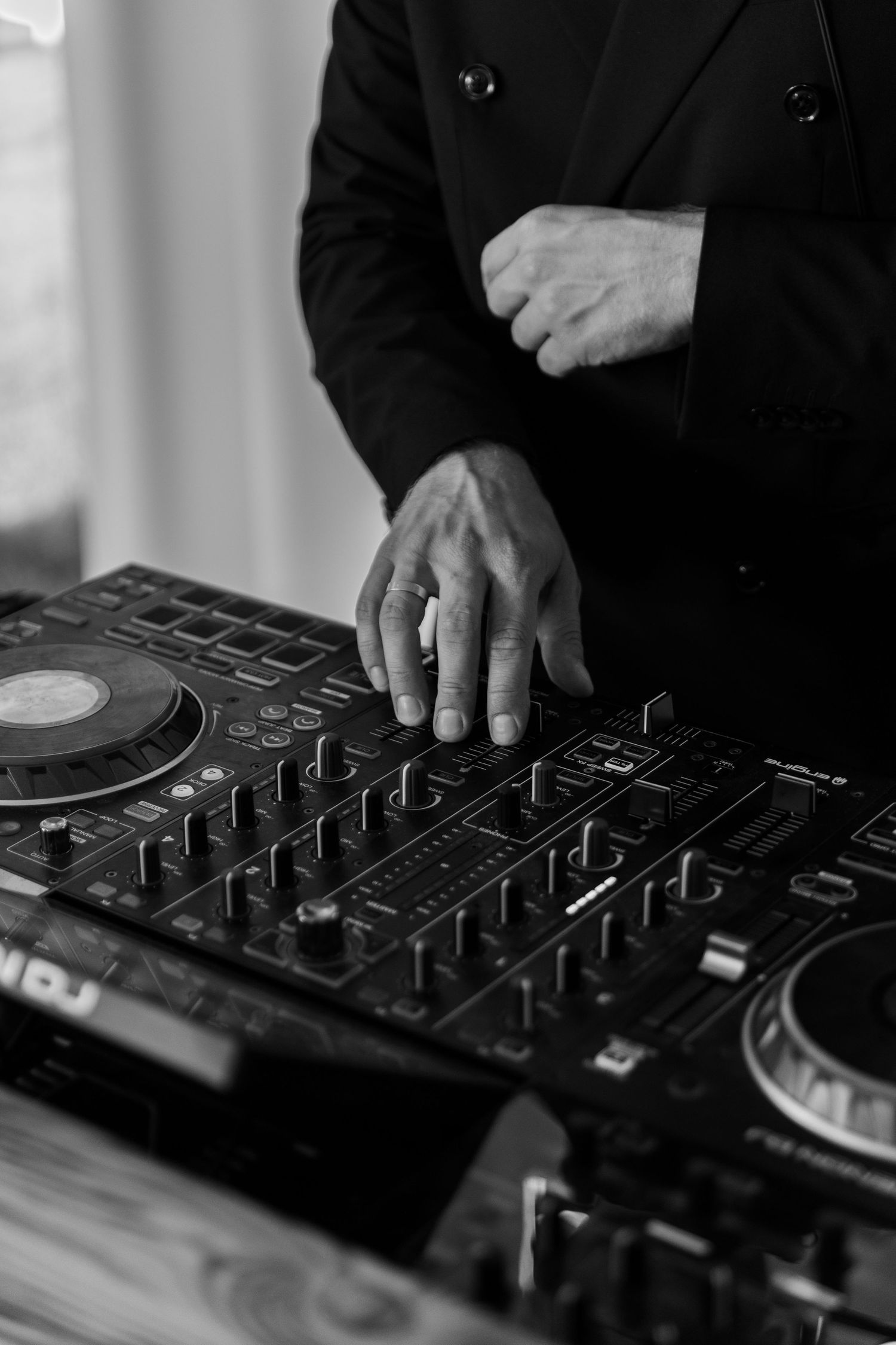 Close-up black and white shots of DJ hands adjusting knobs and controls on professional mixing equipment.