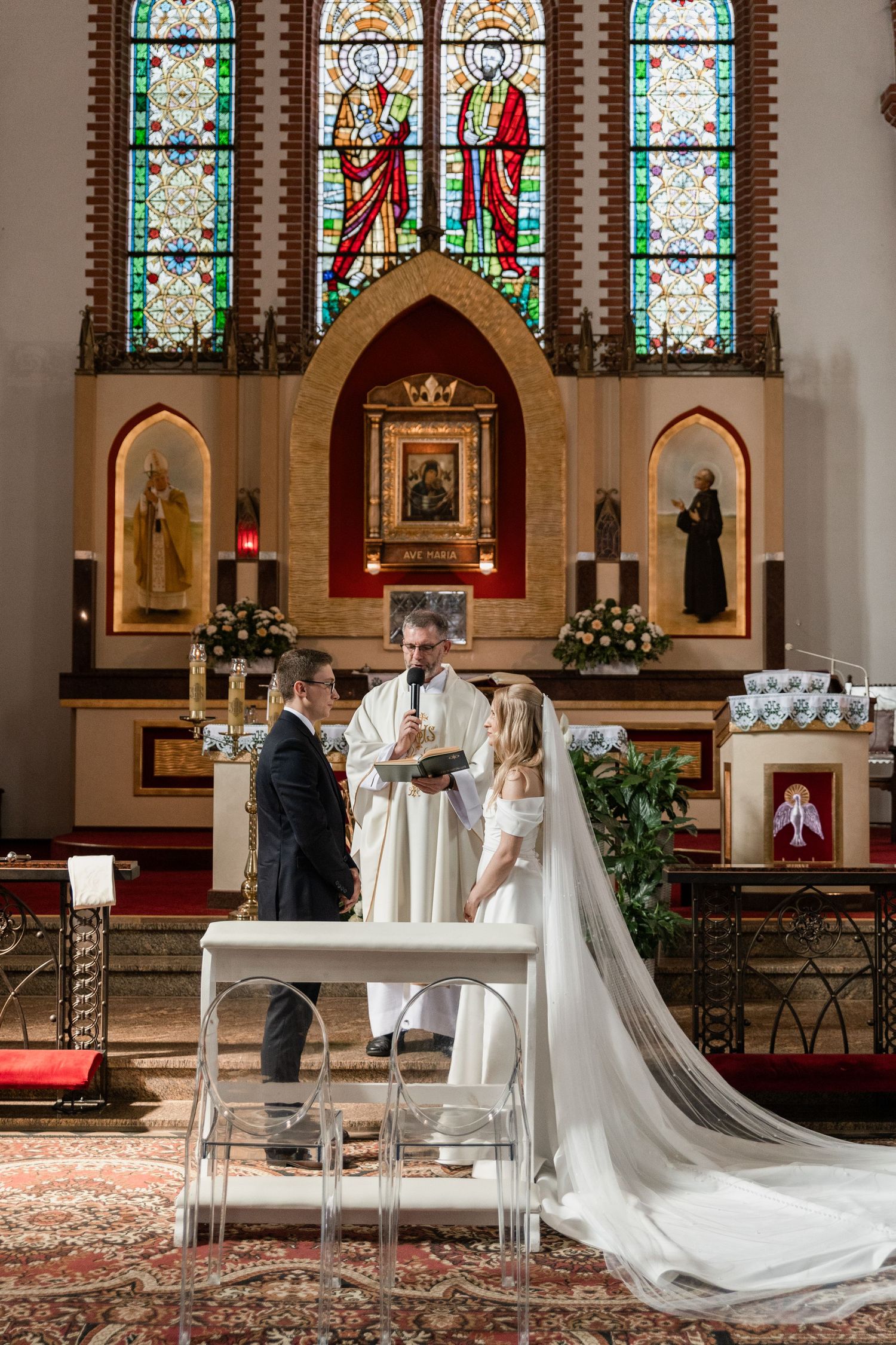 Elegant church wedding ceremony sequence showing signing of marriage documents beneath stained glass windows.