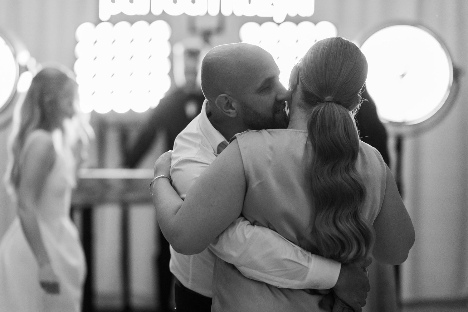 Black and white wedding photos showing romantic moments between couples during their special day.