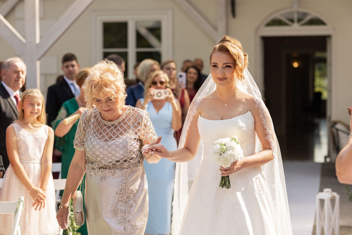 Wedding guests dancing and celebrating together on a dance floor at an outdoor reception venue.