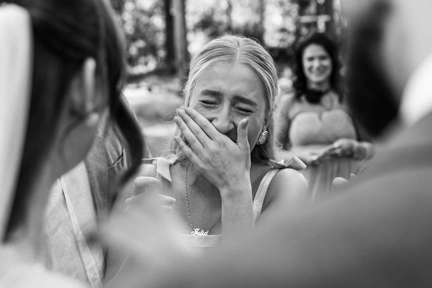A black and white photograph shows guests and friends enjoying themselves at an outdoor wedding ceremony.