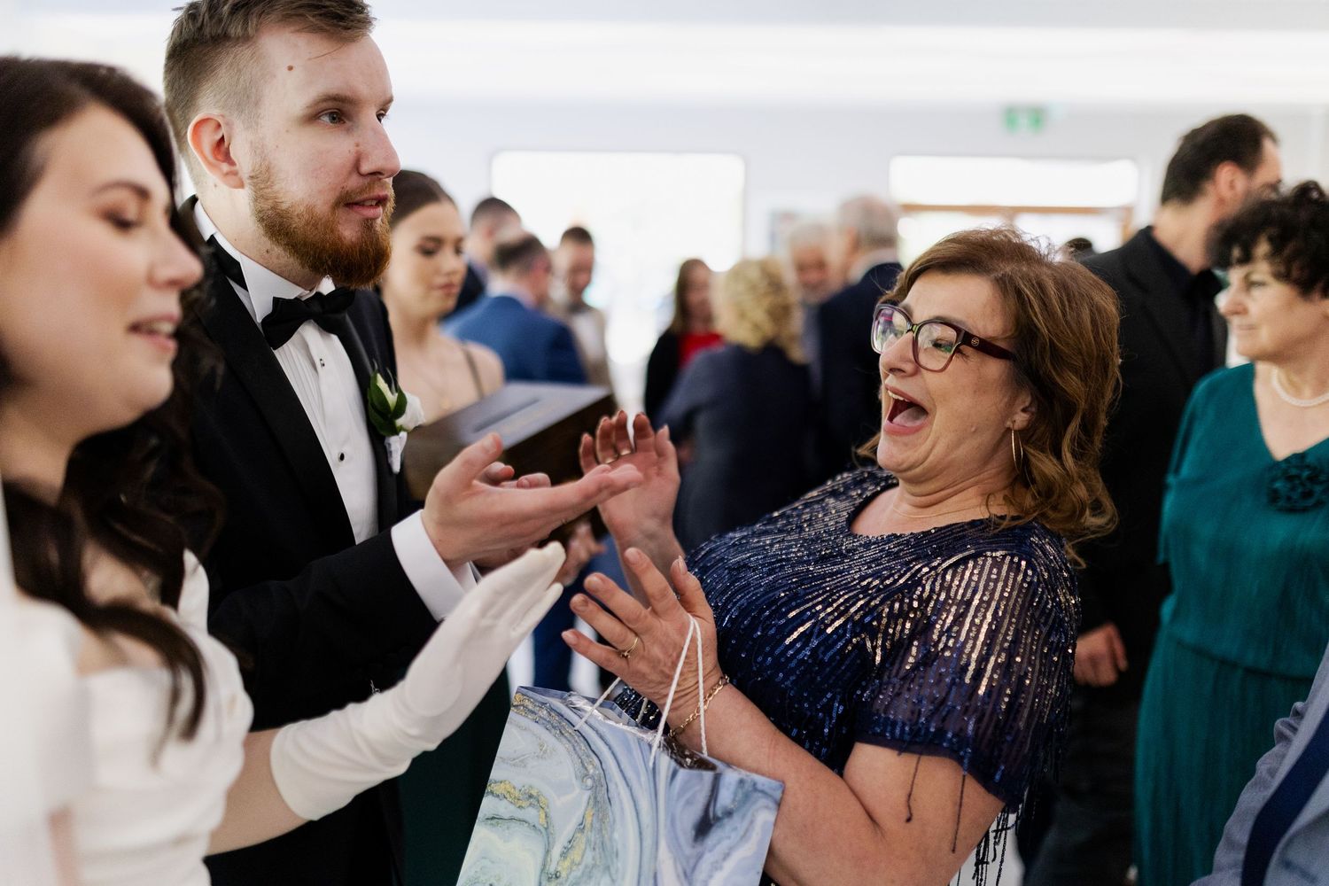 A joyous candid moment of guests dancing and celebrating together at an elegant wedding reception.