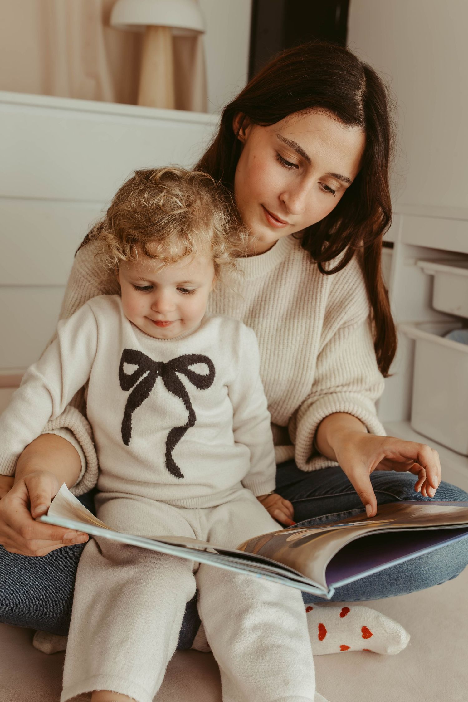 mother reading a book to her toddler daughter