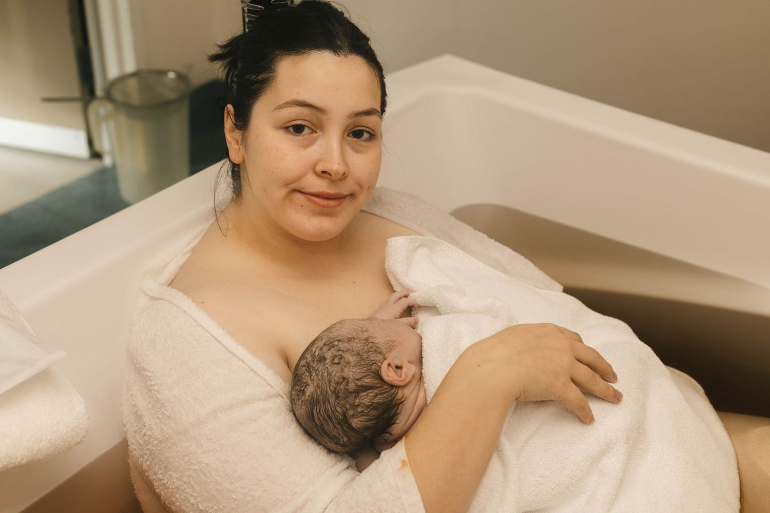 mother holds baby after water birth  birth photography