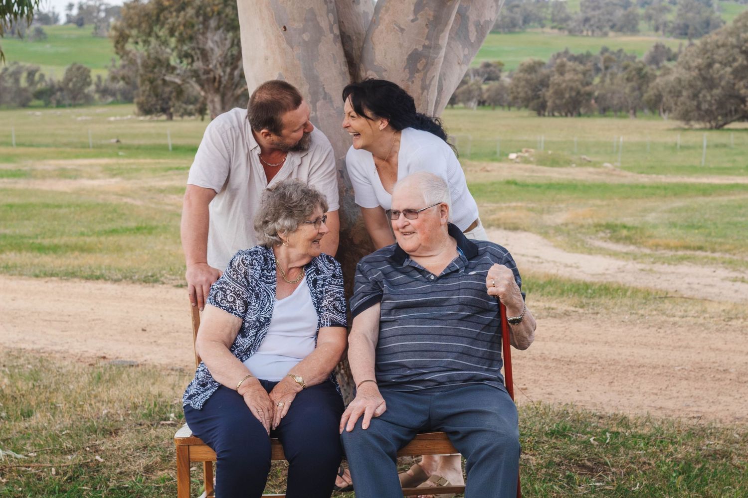 Intimate family portrait under eucalyptus tree showing closeness and affection.