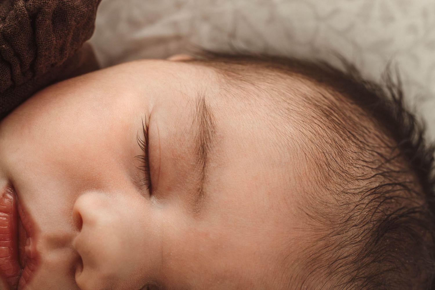 Close-up portrait of a peaceful sleeping baby with soft natural lighting.