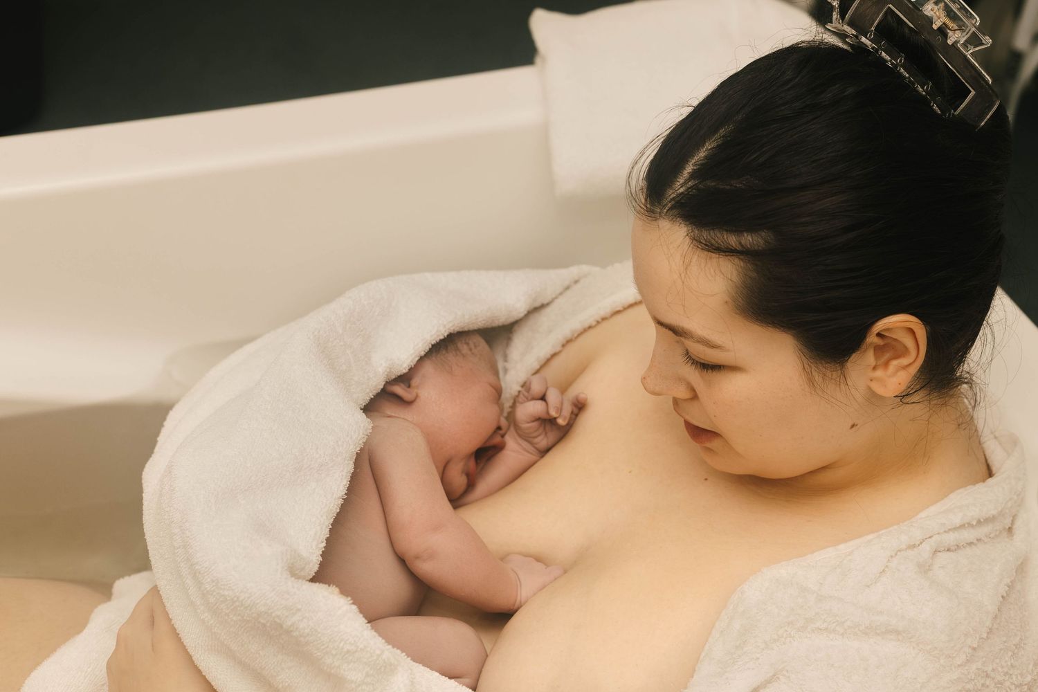 mother holds baby after water birth birth photography