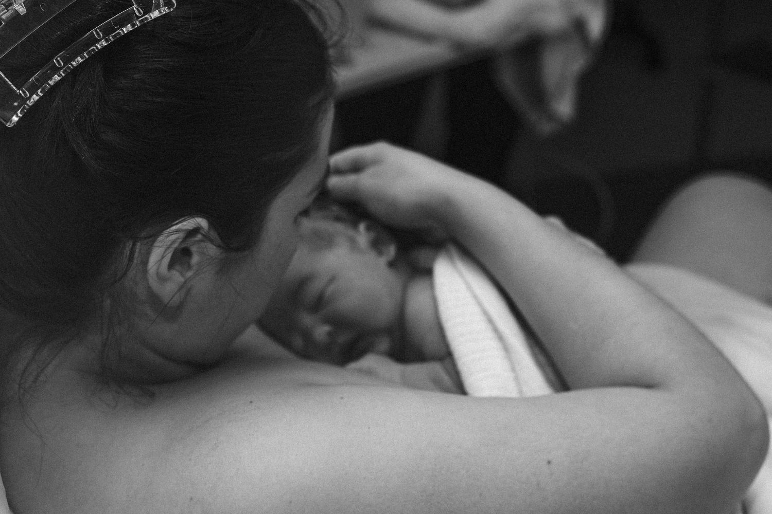mother holds baby after birth black and white birth photography