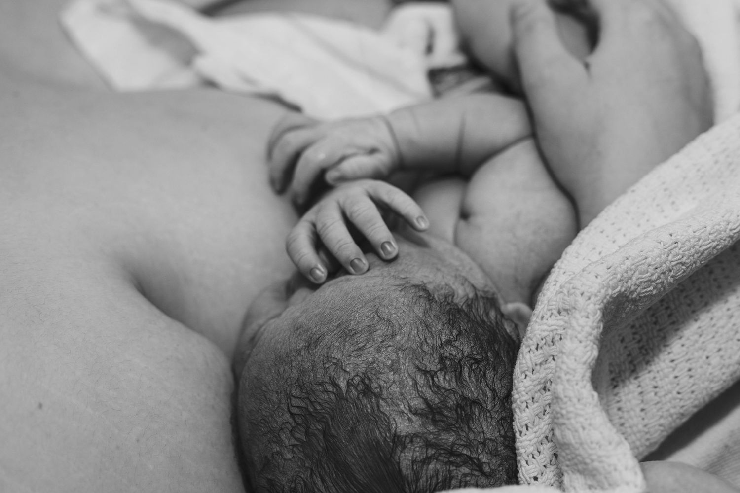 mother holds baby after birth black and white birth photography