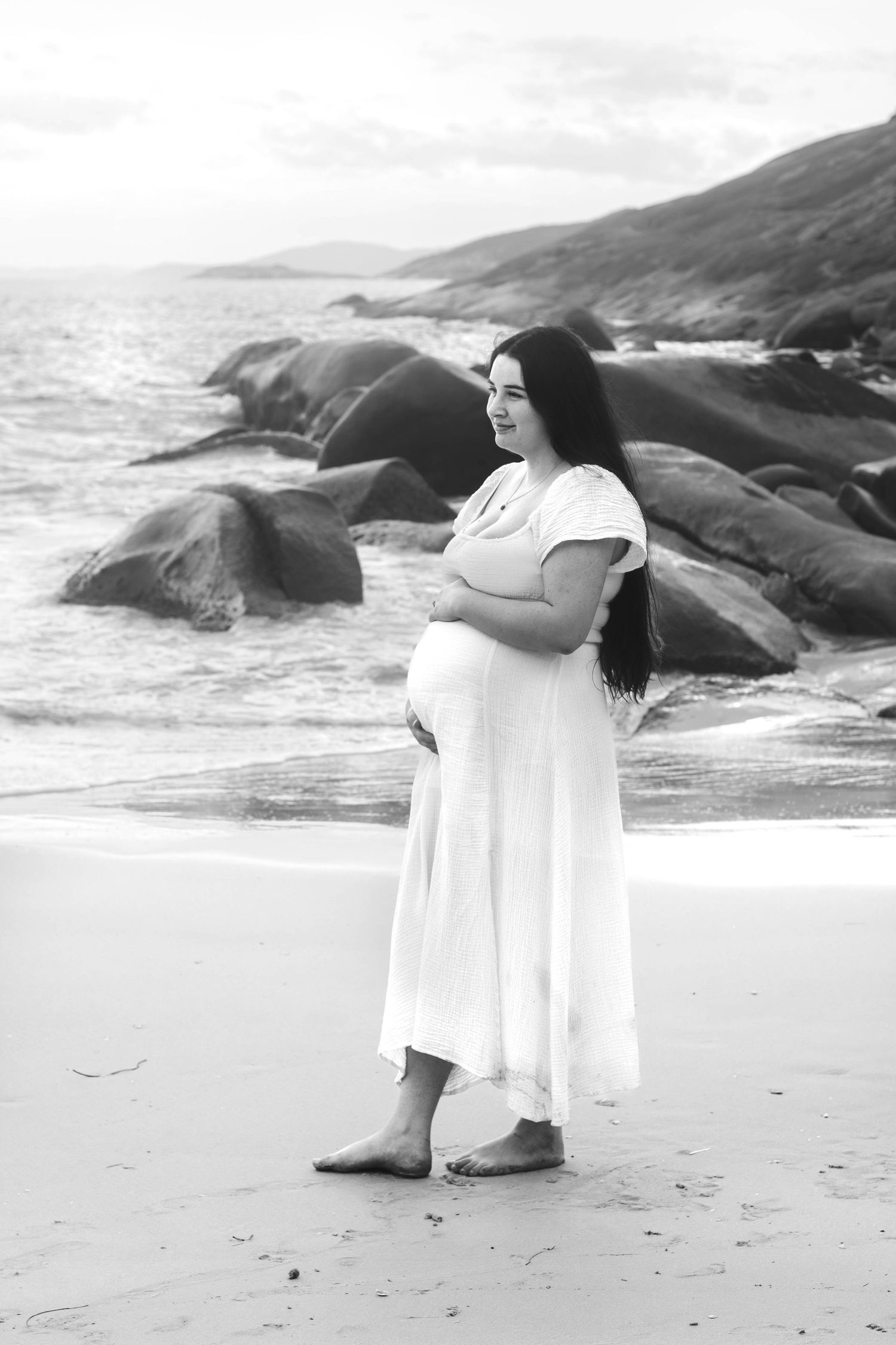 Black and white beach photography with waves and coastal rocks creating a dreamy backdrop.