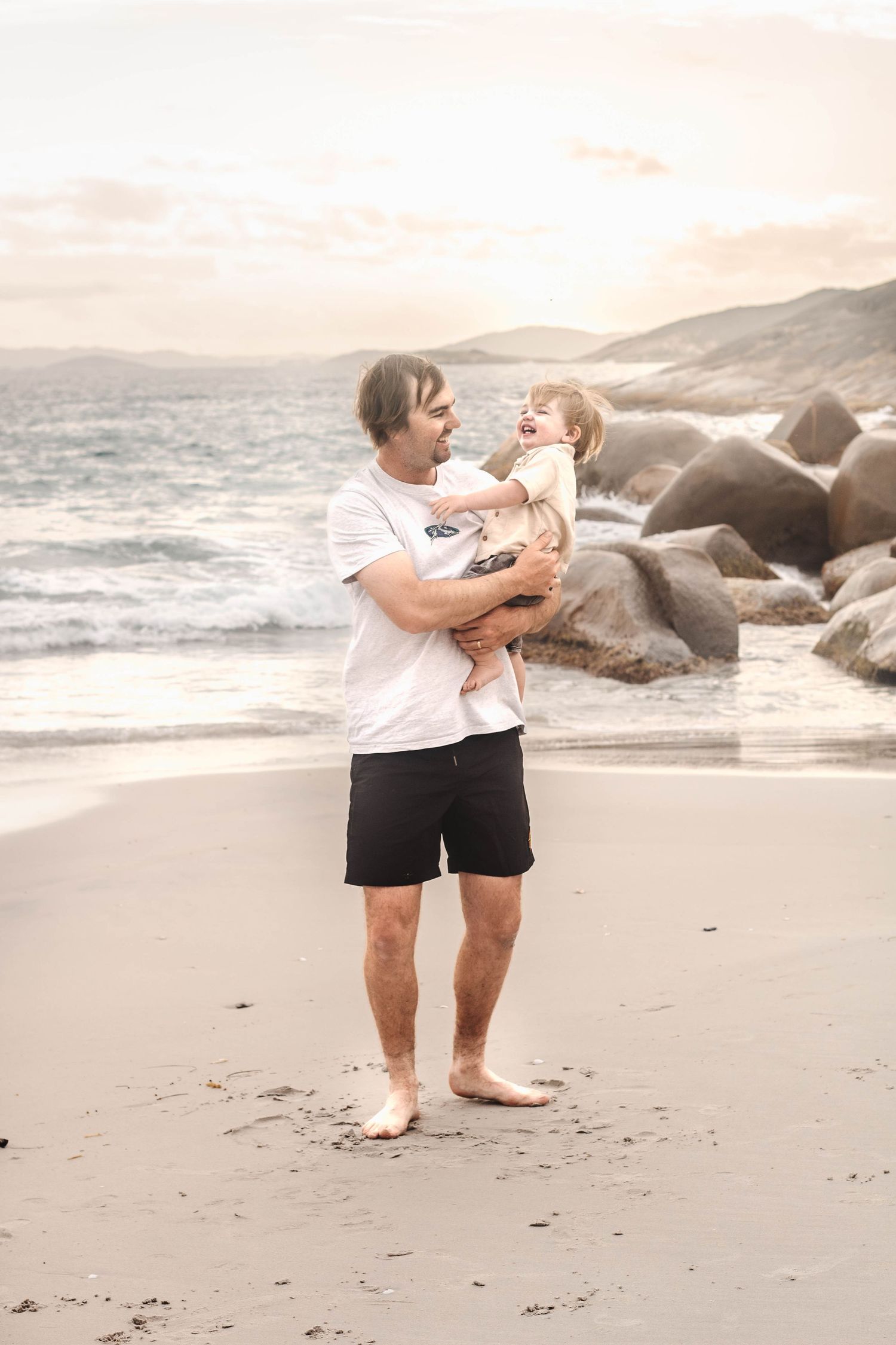 A romantic beach dance sequence captured against coastal rocks and gentle waves.