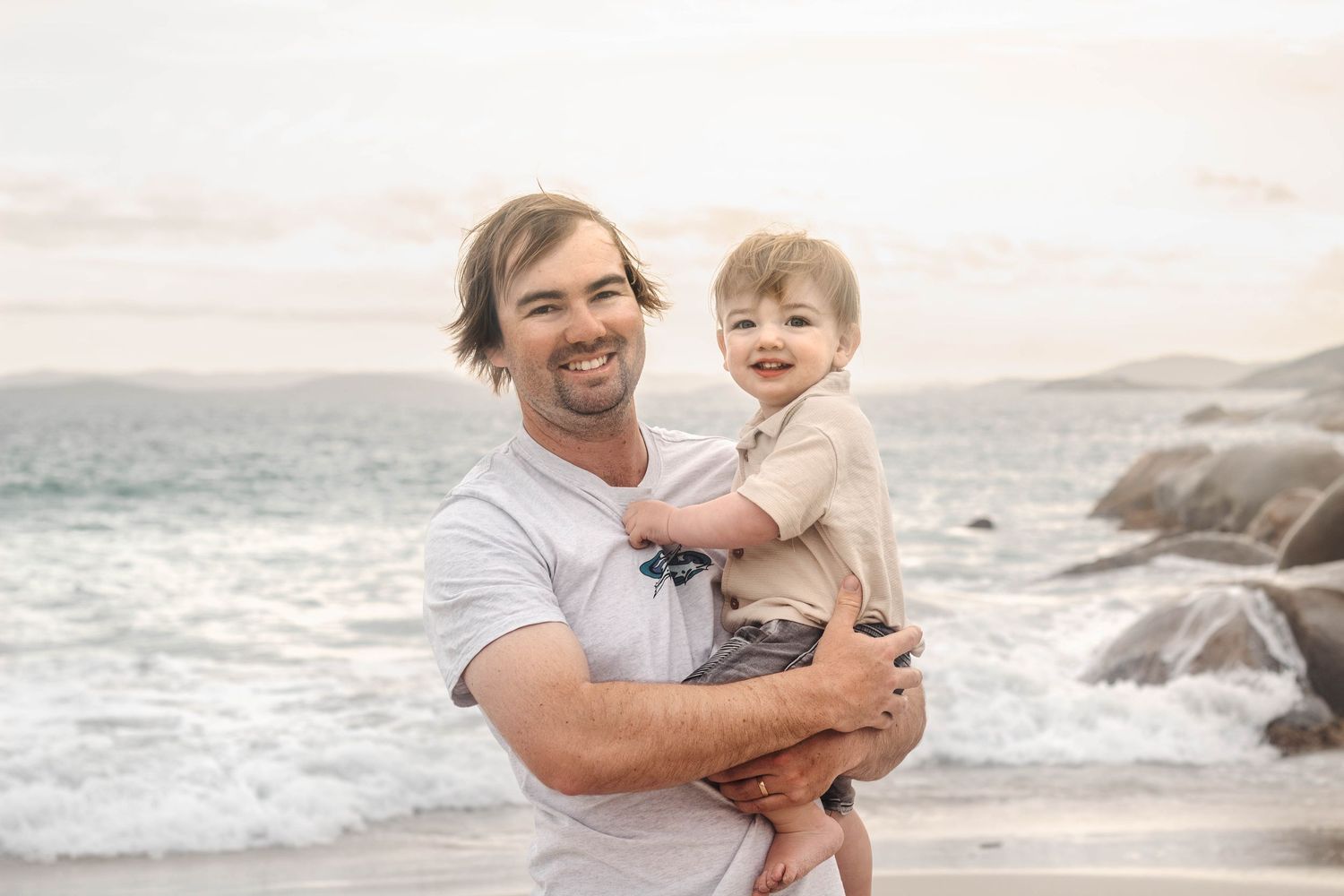 A tender moment captured during a beach dance photoshoot with coastal scenery.