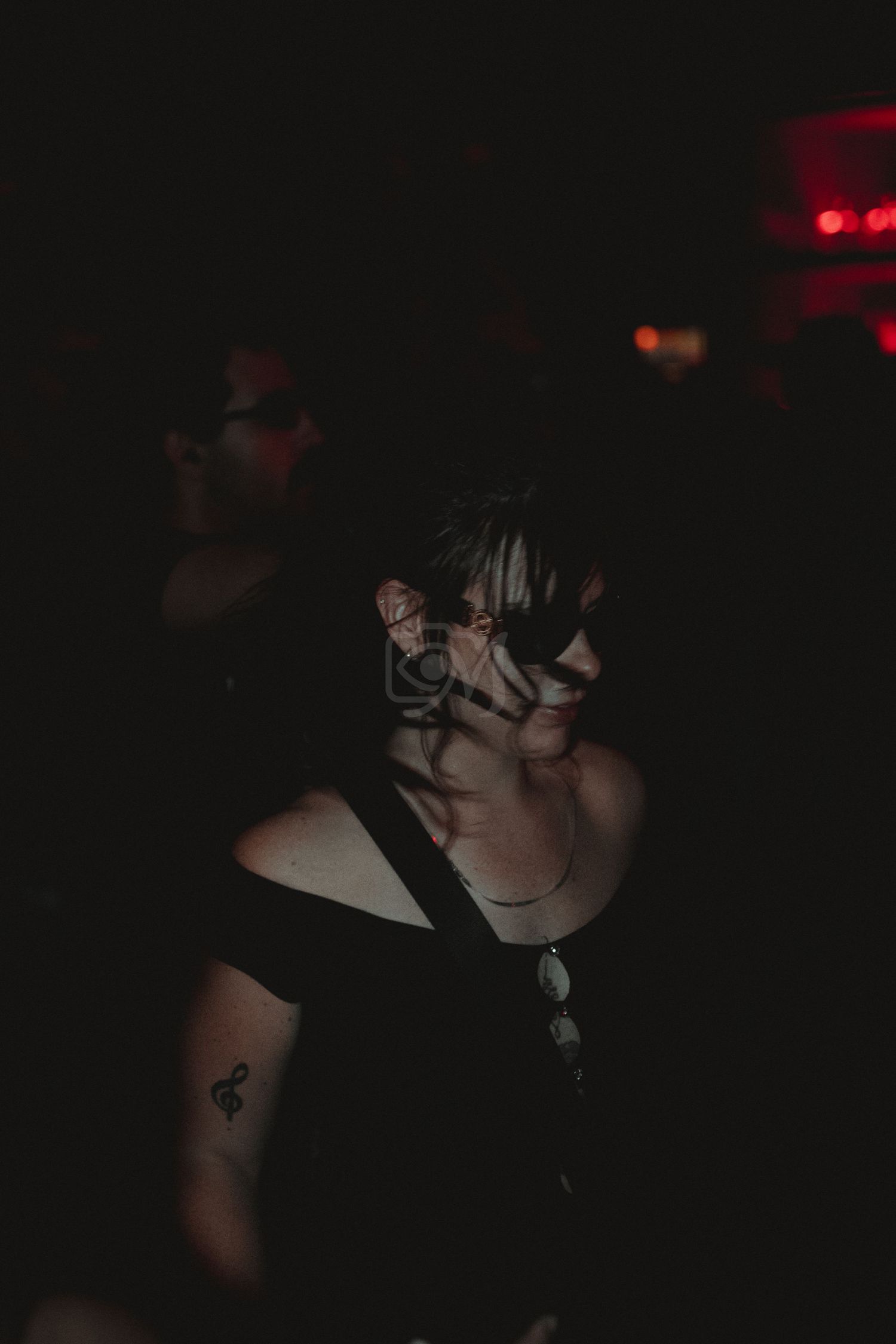 Atmospheric shot of someone dancing in dark club with minimal lighting.