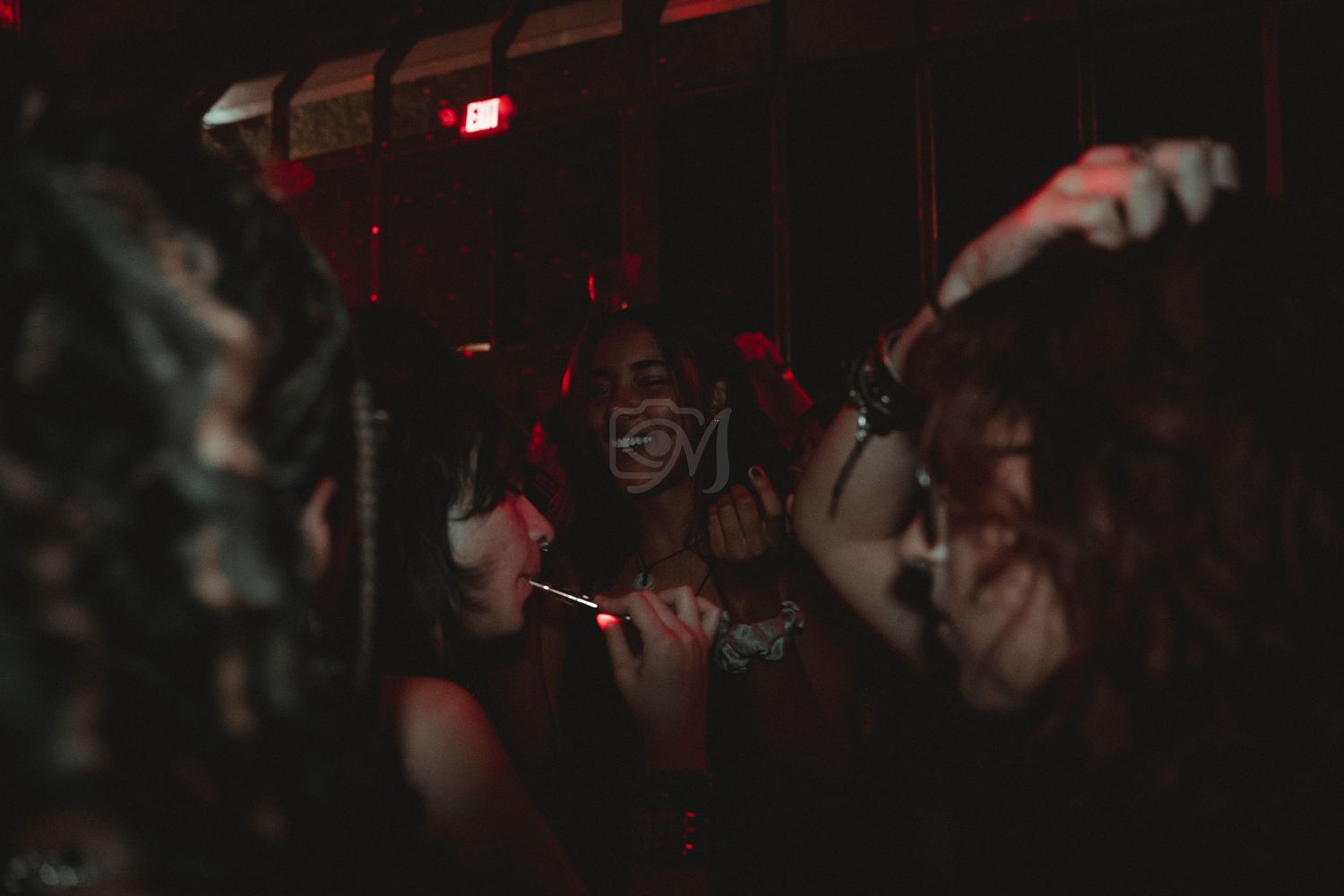 Dark nightclub scene with performers dancing in atmospheric lighting.